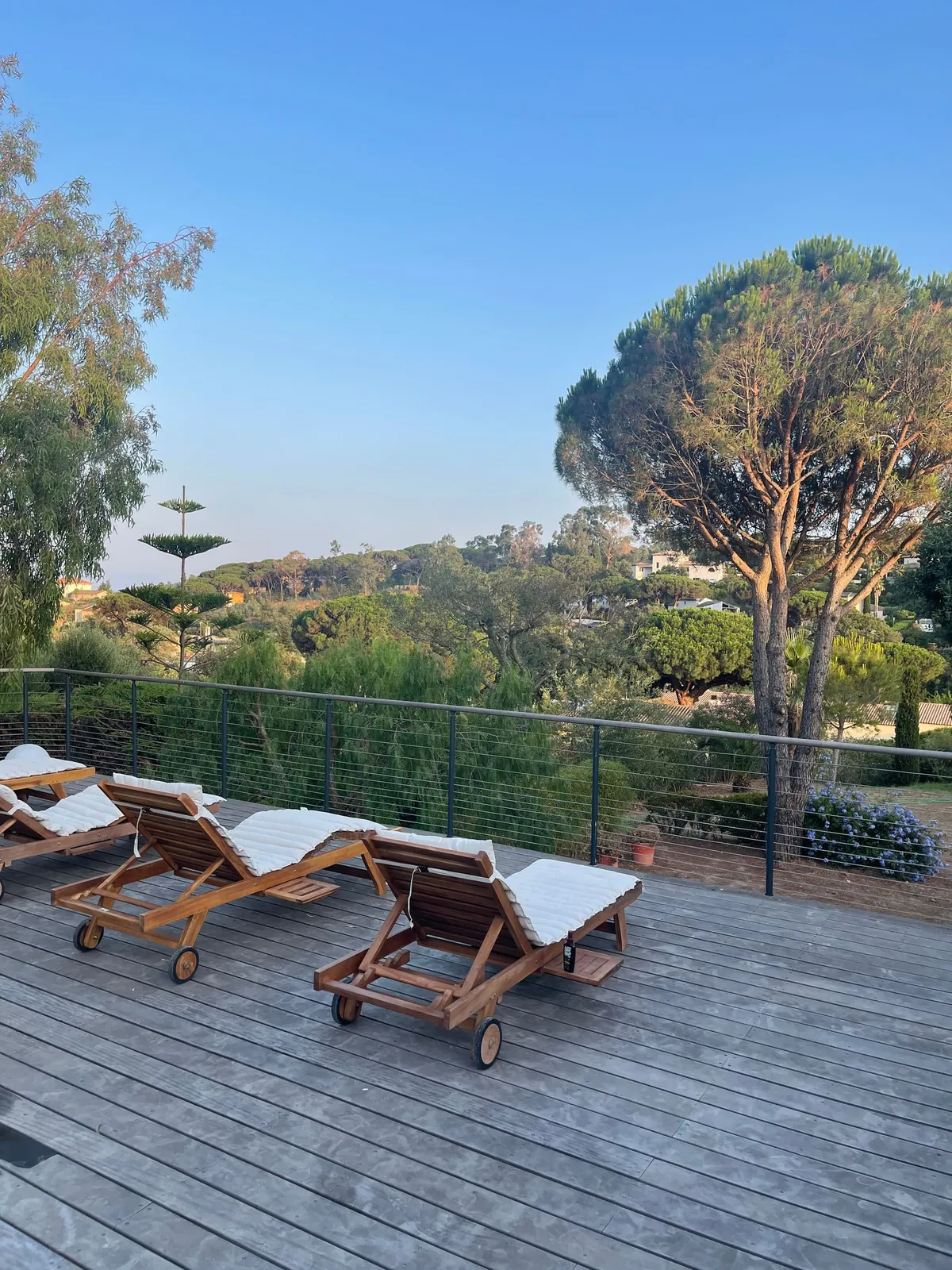La terrasse en bois et ses transats, face aux collines