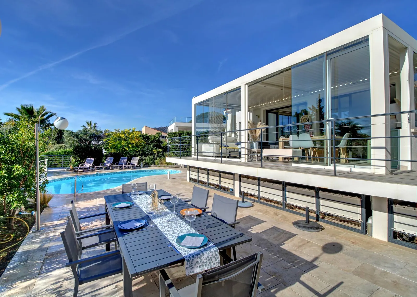 La table de la terrasse, devant la véranda vitrée