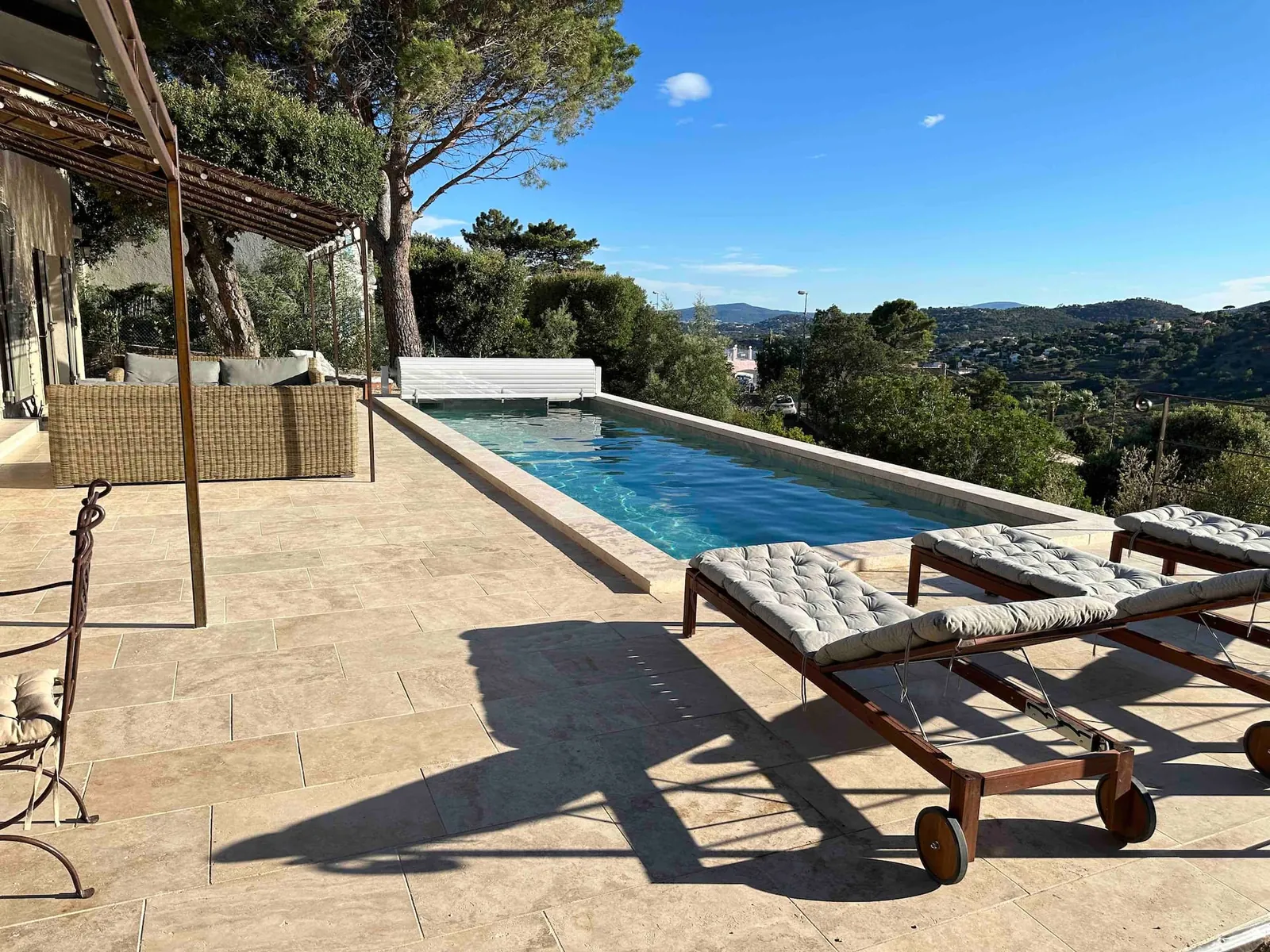La piscine et ses transats, face aux collines